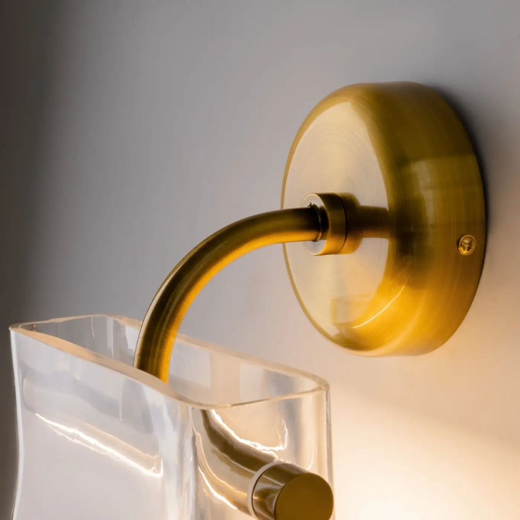 Applique murale LED finition laiton, abat-jour en verre transparent