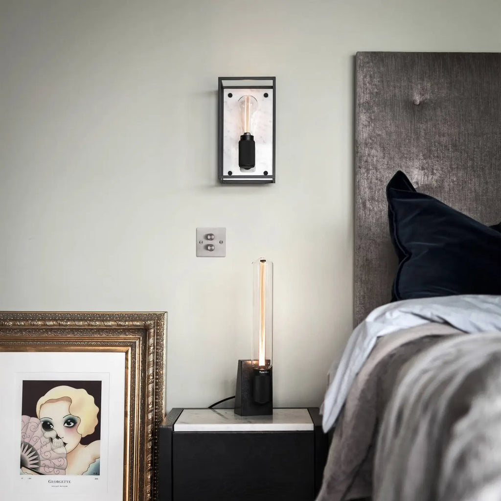 Applique murale cage en acier noir mat sur fond de marbre poli