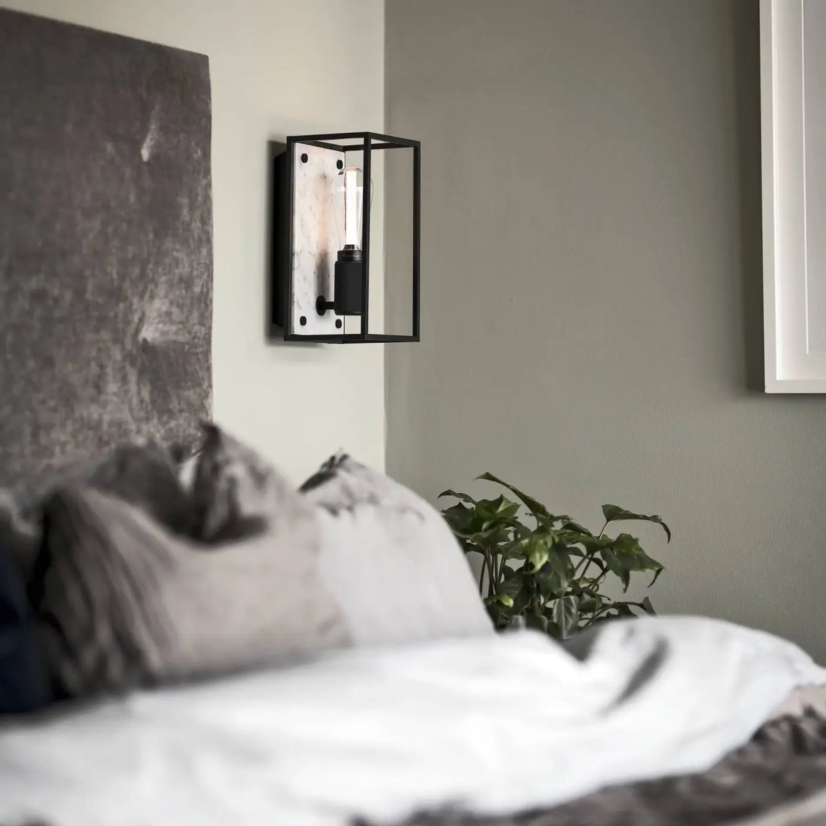 Applique murale cage en acier noir mat sur fond de marbre poli