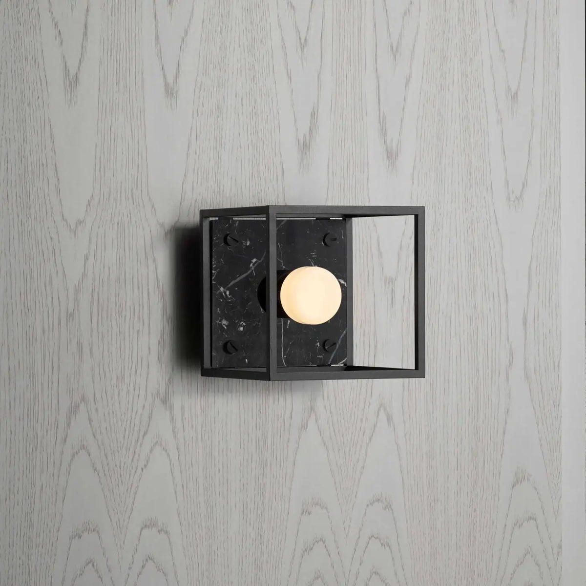 Applique murale cage en acier noir mat sur fond de marbre poli, noir