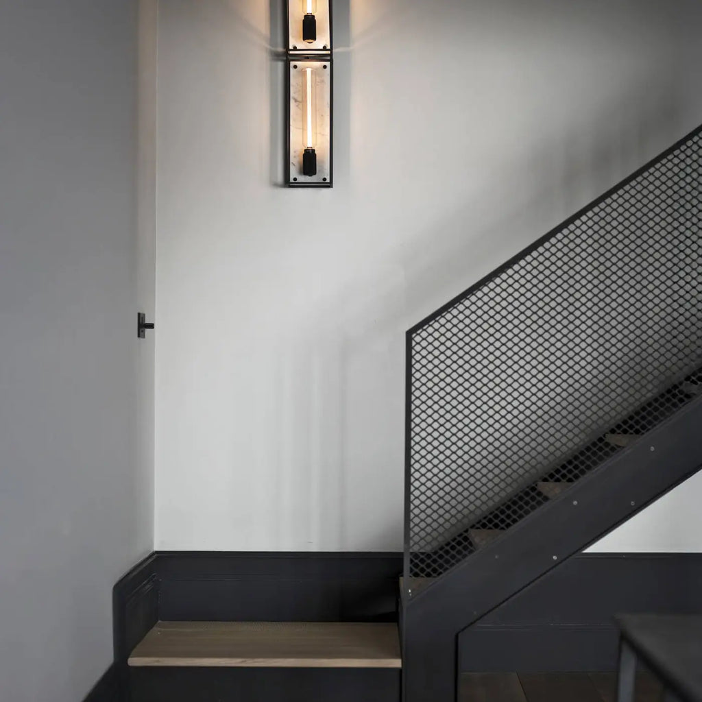 Applique murale cage en acier noir mat sur fond de marbre poli