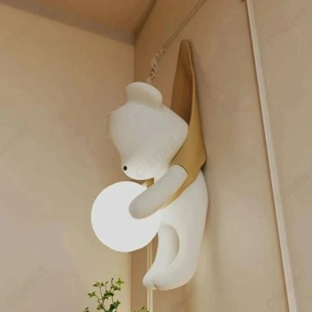 Applique murale petit ours suspendu tenant une sphère lumineuse, jaune
