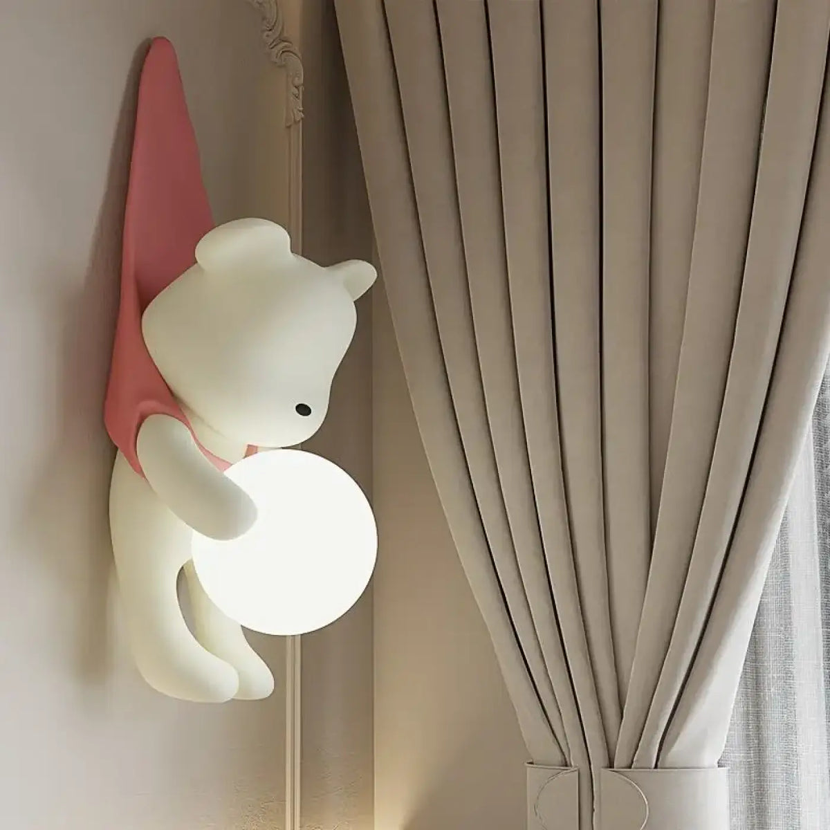 Applique murale petit ours suspendu tenant une sphère lumineuse, rose