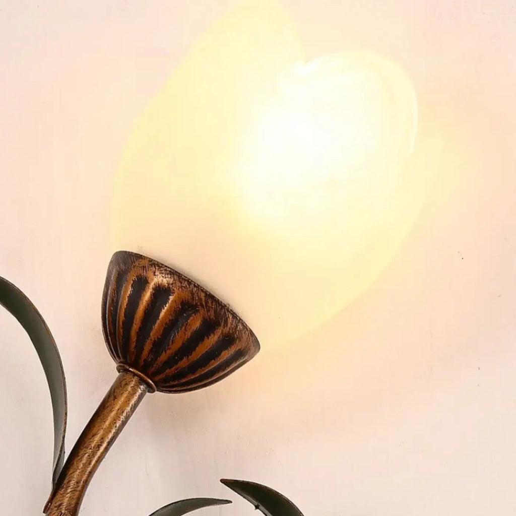 Applique murale fleur dorée avec globe en verre blanc