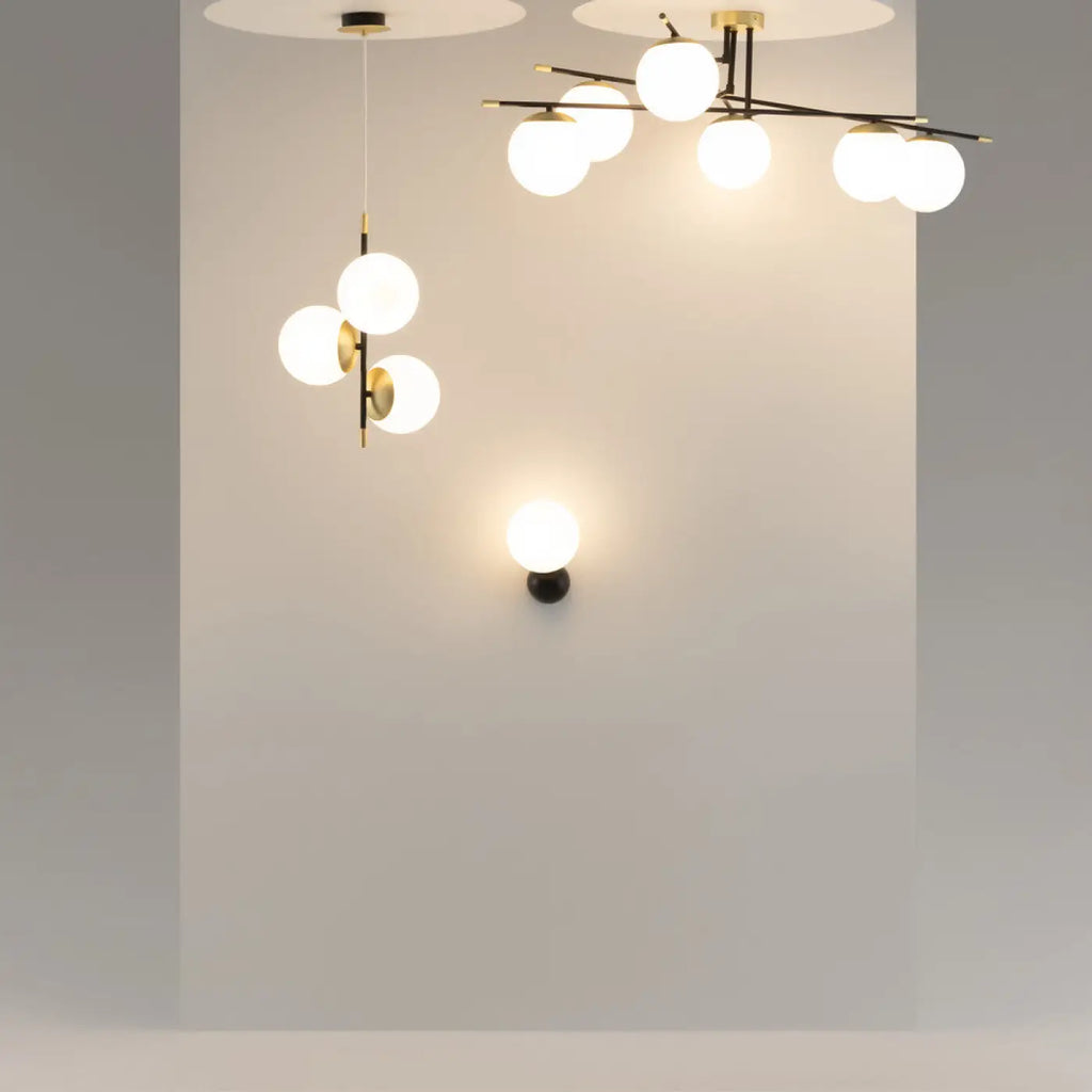 Applique murale globe opalin sur bras noir et doré, culot E14