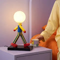 Lampe à poser figurine colorée portant un globe lumineux
