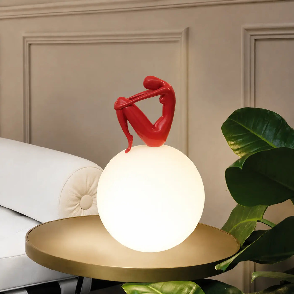 Lampe sculpture, silhouette enlaçant une sphère lumineuse, rouge