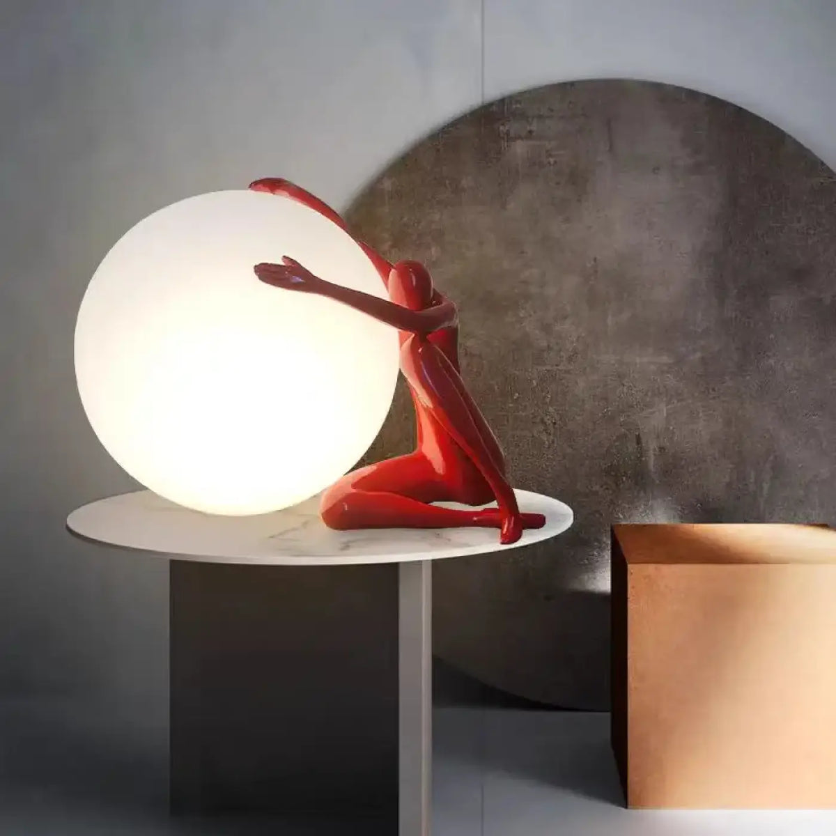 Lampe sculpture, silhouette enlaçant une sphère lumineuse, rouge