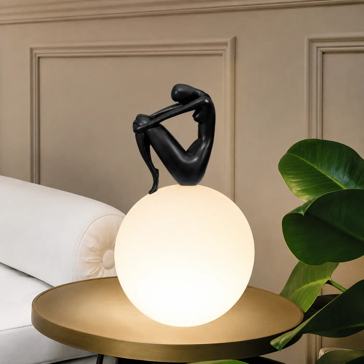 Lampe sculpture, silhouette enlaçant une sphère lumineuse, noir
