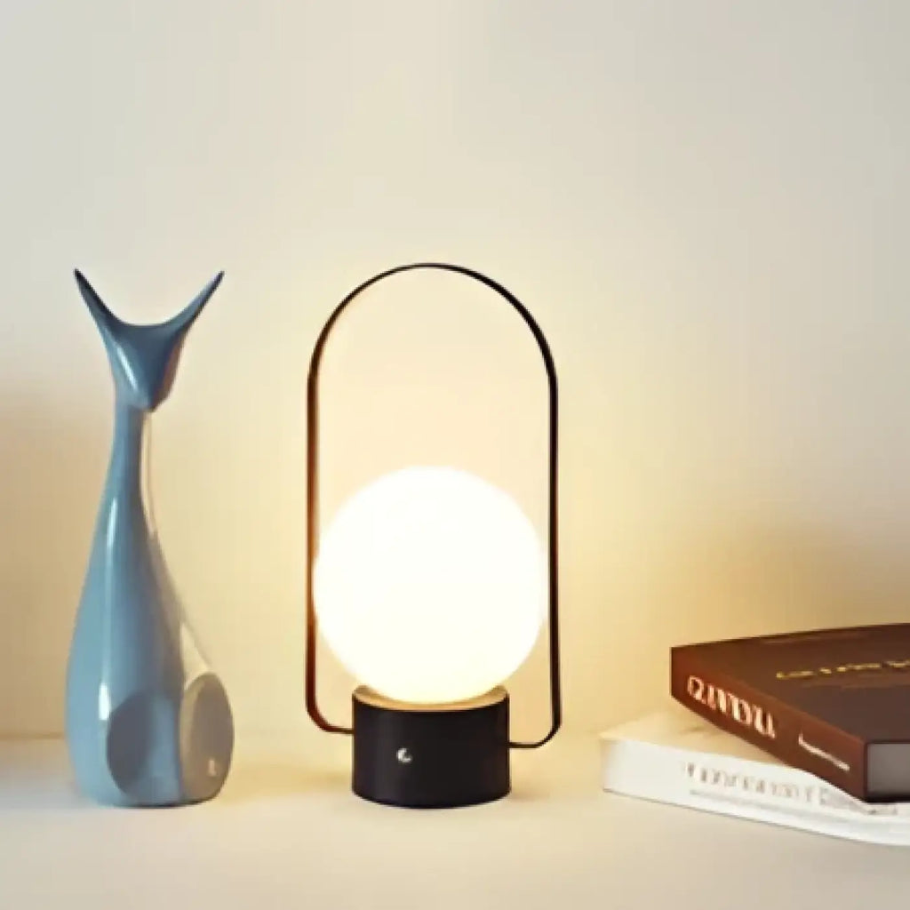 Lampe à poser sphère lumineuse sous arche métallique