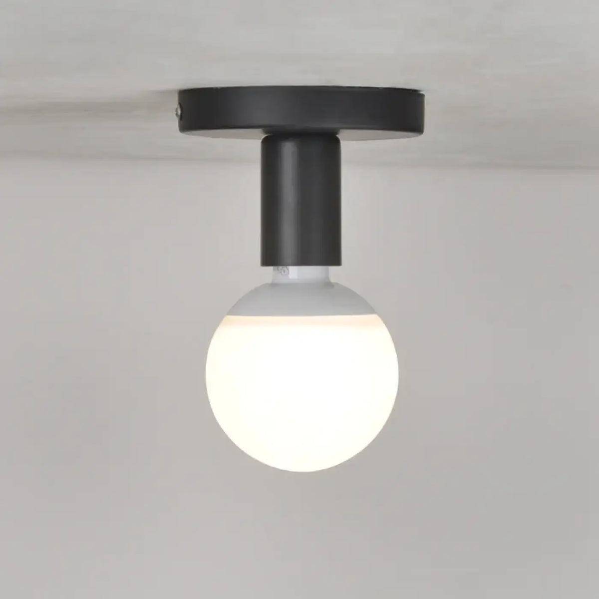 Plafonnier minimaliste noir avec ampoule globe apparente