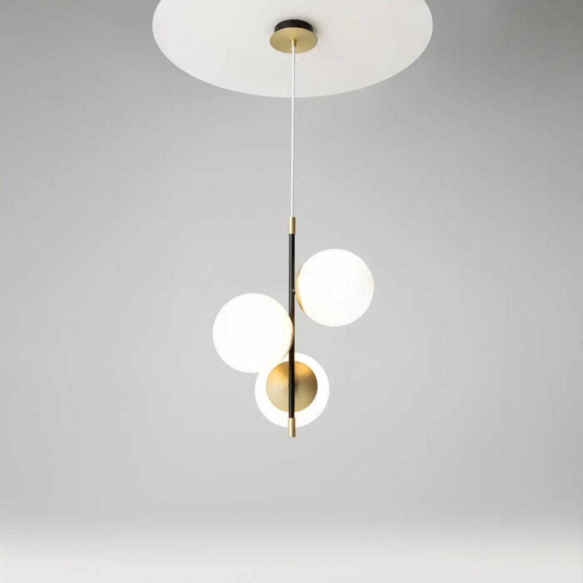 Suspension à trois globes en verre opalin, acier noir et doré