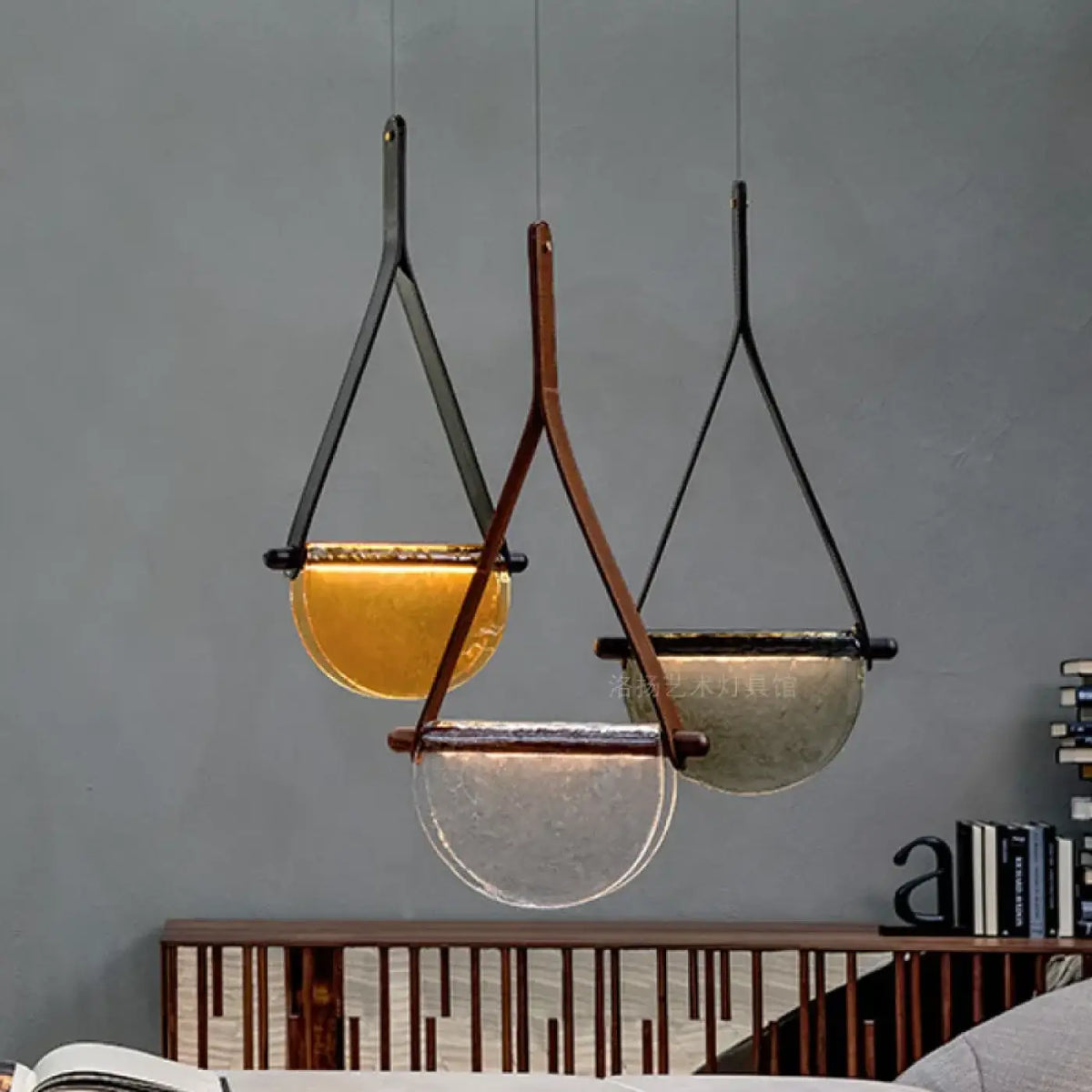 Suspension en verre soufflé tenue par une sangle en cuir